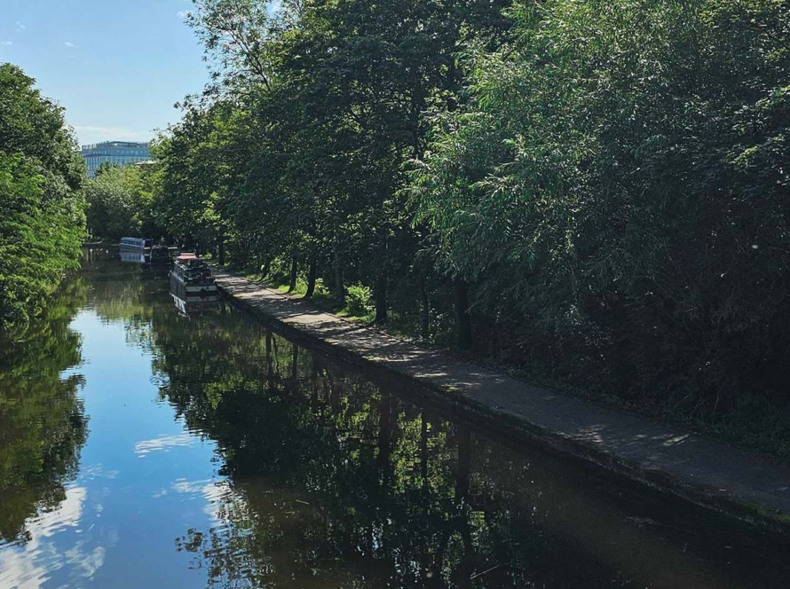 View of Nottingham canal with trees and blue sky.