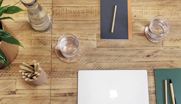 Laptop, phone, to do list pad on white desk