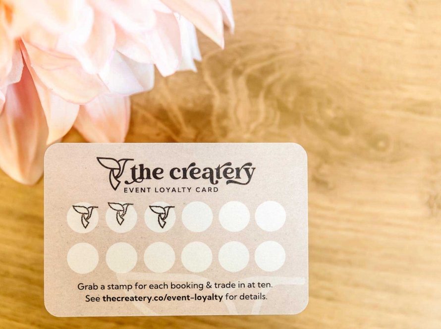 Stamped Createry loyalty card on wooden background