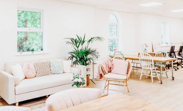 Coworking floor with desks, sofa and chairs.