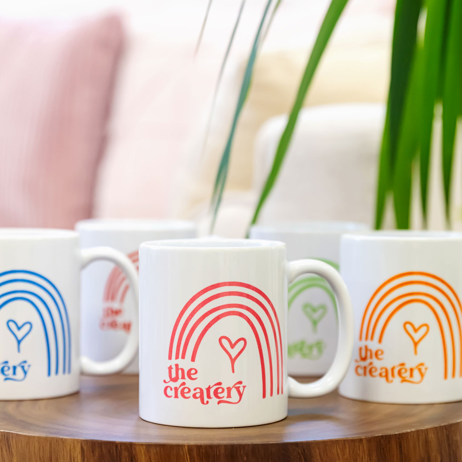 Rainbow Createry mugs on a table