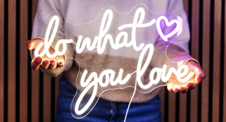 Sabrina holding a do what you love neon sign
