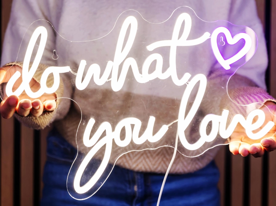 Sabrina holding a do what you love neon sign