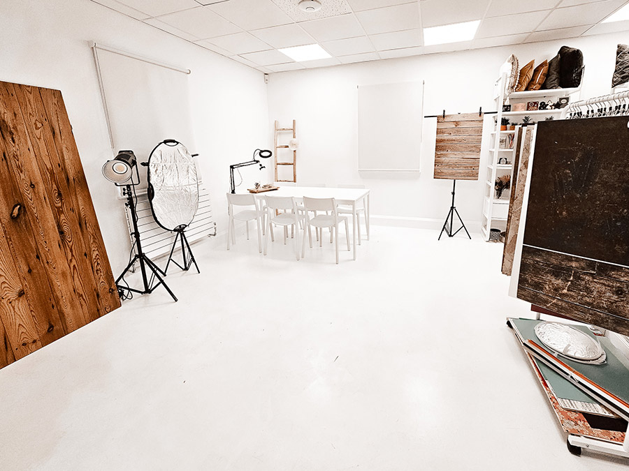 White photography studio with lights, table and backdrop.